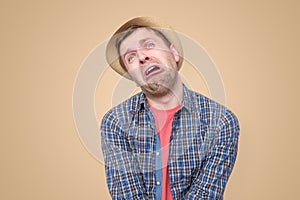 Sad man in summer hat looking upset ready to cry, with hopeless facial expresion photo