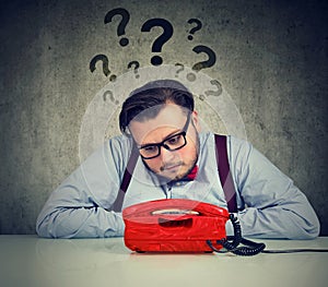 Worried man with too many questions waiting for a call photo