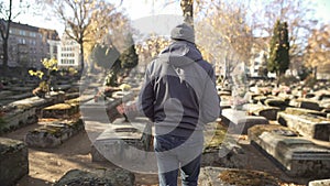 Sad man walking on ancient cemetery, visiting relative, commemorating ancestors photo