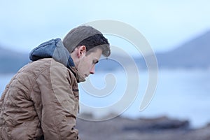 Sad man in winter on the beach complaining