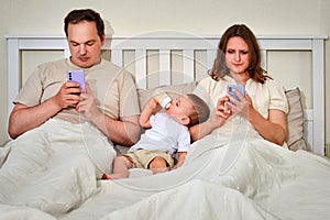 Sad man and woman with toddler baby looking in a mobile phone. Fath