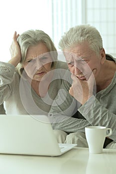 Sad Mature couple with laptop