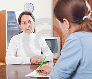 Sad mature woman filling questionnaire for employee
