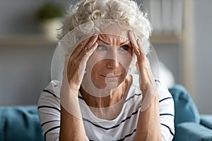 Sad mature woman touching temples close up, feeling unwell