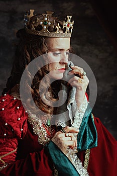 sad medieval queen in red dress with handkerchief crying