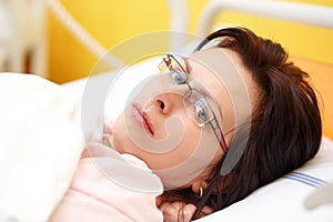 Sad middle-aged woman lying in hospital