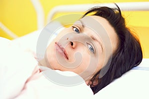 Sad middle-aged woman lying in hospital