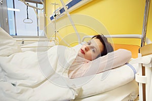 Sad middle-aged woman lying in hospital