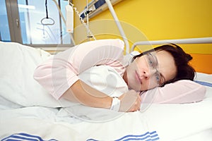 Sad middle-aged woman lying in hospital