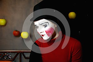 Sad mime in a hat with apples