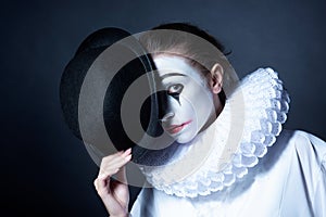 Sad mime Pierrot holding a black hat