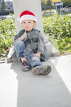 Sad Mixed Race Boy With Santa Hat and Candy Cane