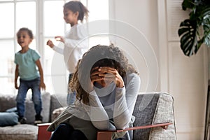 Sad mother and playful children at home