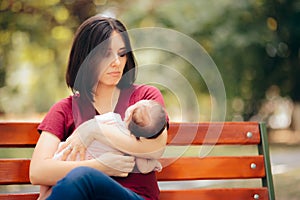 Sad Mother Suffering from Post Partum Depression Holding Baby