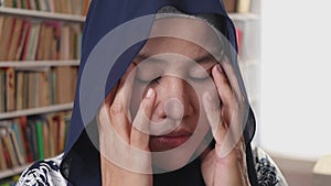 Sad muslim woman contemplating something while in library