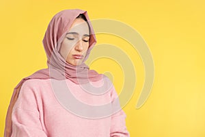 Sad muslim woman standing with eyes closed