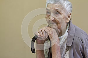 Sad old lady contemplating with walking stick