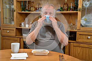 Sad old man, self isolated and eating alone