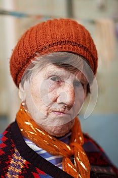 Sad old woman in red beret