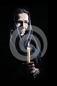 Sad old woman Senior in sorrow with candle