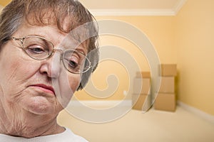 Sad Older Woman In Empty Room with Boxes
