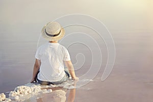 Sad and pensive boy sitting on the beach