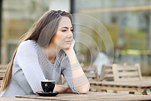 Sad pensive woman looking away on a coffee shop