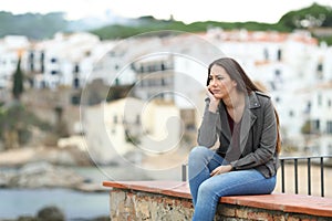 Sad pensive woman looking away in a town