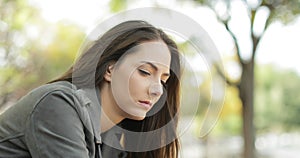 Sad pensive woman sitting in a park