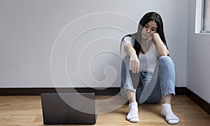 Sad, pensive young girl with her cell phone about to fall to the floor