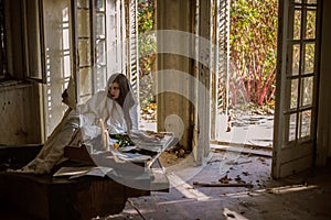 Sad pianist playing broken piano at abandoned house