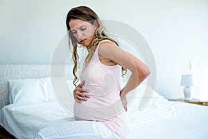 sad pregnant woman with back pain