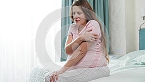 Sad pregnant woman sitting and shaking on bed. Concept of maternal and pregnancy depression.