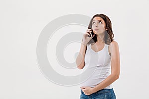 Sad pregnant woman talking by mobile phone