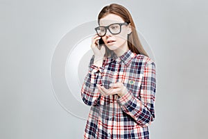 Sad pretty teenage girl standing and talking on cell phone