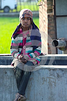 SAD RURAL GIRL SITTING ON A TUBE WELL AFTER WORKING AS CHILD LABOUR