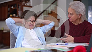 Sad schoolboy closing ears with hands as angry woman shouting scolding. Portrait of exhausted tired Caucasian son with