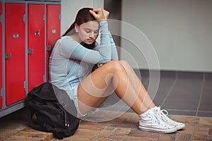 Sad schoolgirl sitting in locker room