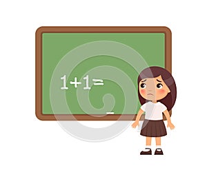 Sad schoolgirl is standing in front of a blackboard. Kid cannot solve the example.