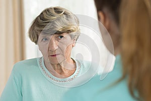 Sad senior female in nursing home
