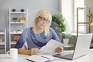 Sad senior lady reading utility bill, bank account balance notification or novel rejection letter