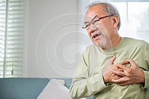 Sad senior man feeling bad pain use hand touching chest having heart attack