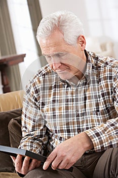 Sad Senior Man Looking At Photograph