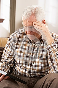 Sad Senior Man Looking At Photograph