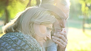 Sad senior wife embracing crying husband, relative loss, grief and sorrow