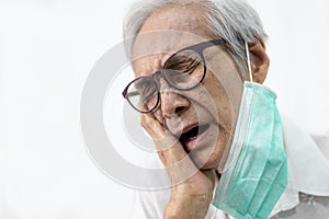 Sad senior woman holding her hand on her aching tooth,asian elderly suffering from toothache and tooth decay,old people having