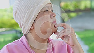 Sad, senior woman and person with Cancer sitting in a wheelchair, stress and crying into her hands at the hospital park,