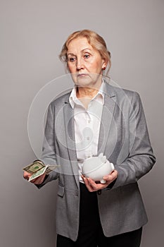 Sad senior woman with us dollars money