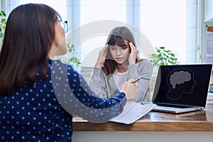 Sad, serious teenage girl at session in office of mental professional