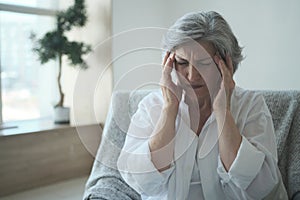 Sad sick elderly woman with headache pain despairing worried about medical problem injury,